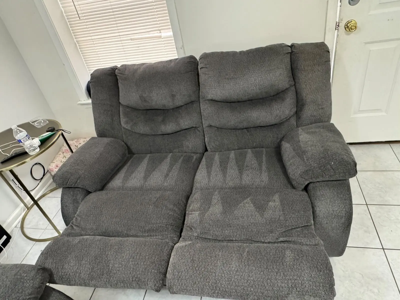 Freshly cleaned gray loveseat with visible extraction lines by KC Pro Cleaning